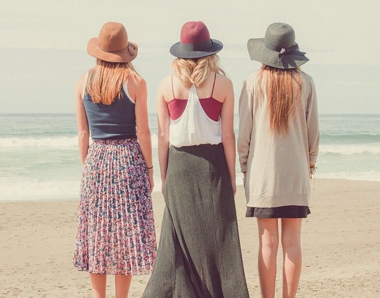 Tres mujeres de espaldas frente al mar
